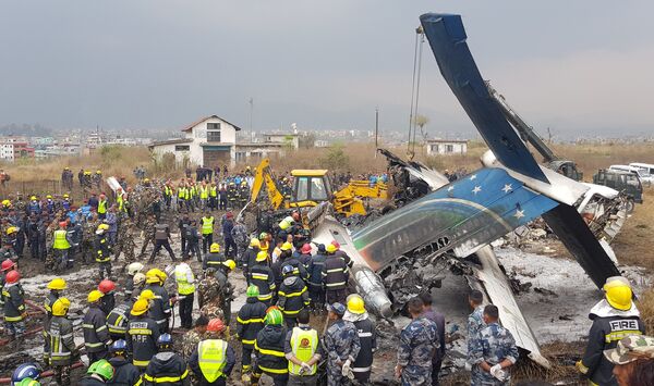 Спасатели на месте крушения самолета авиакомпании US-Bangla Airlines в Катманду, Непал. 12 марта 2018