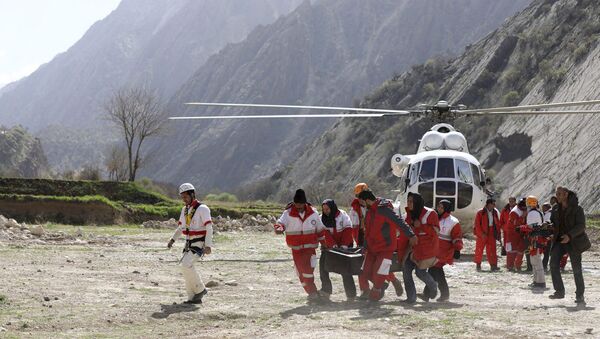 Члены спасательной команды несут тело пассажира турецкого частного самолета, который разбился в горах Загрос в Иране. 12 марта 2018