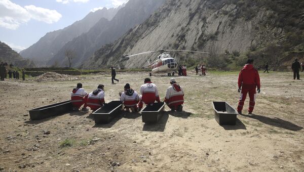 Члены спасательной команды ждут погрузки тел пассажиров турецкого частного самолета, который разбился в горах Загрос в Иране. 12 марта 2018