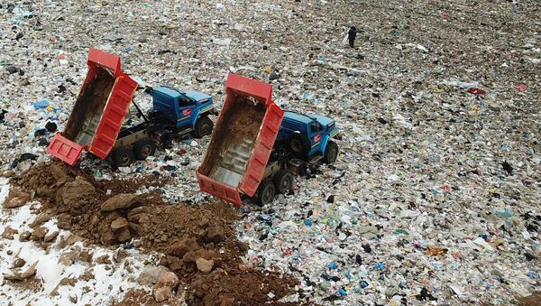 Сотрудники полигона твердых бытовых отходов Ядрово в Московской области засыпают грунтом площадку полигона для нейтрализации неприятных запахов