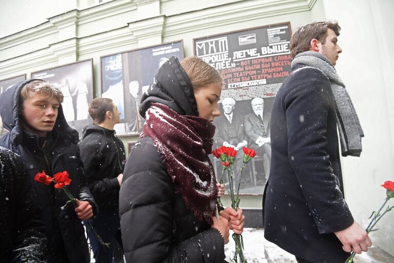 Люди с цветами у входа в здание Московского Художественного театра (МХТ) имени А. П. Чехова в Камергерском переулке, где проходит церемония прощания с актером Олегом Табаковым