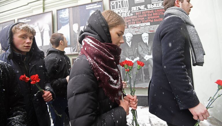 Люди с цветами у входа в здание Московского Художественного театра (МХТ) имени А. П. Чехова в Камергерском переулке, где проходит церемония прощания с актером Олегом Табаковым