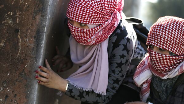 Девушки с масками во время столкновений с израильскими солдатами. Архивное фото