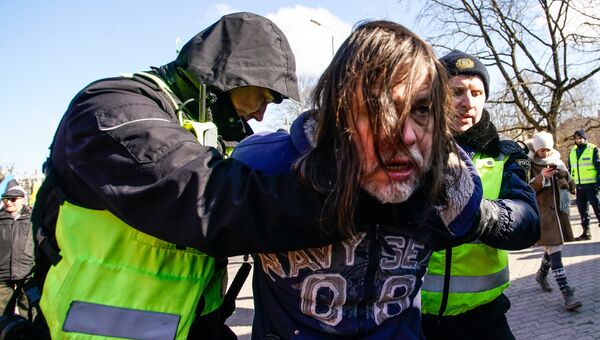 Полицейские задерживают мужчину, протестовавшего против проведения марша бывших латышских легионеров Ваффен СС в Риге. 16 марта 2018