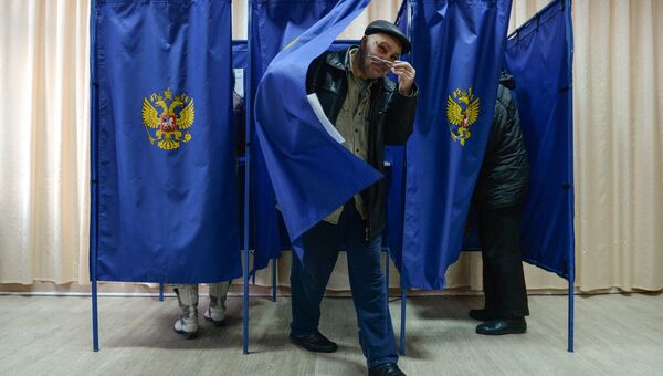 Мужчина выходит из кабинки во время голосования на выборах президента Российской Федерации на избирательном участке в Новосибирске. 18 марта 2018