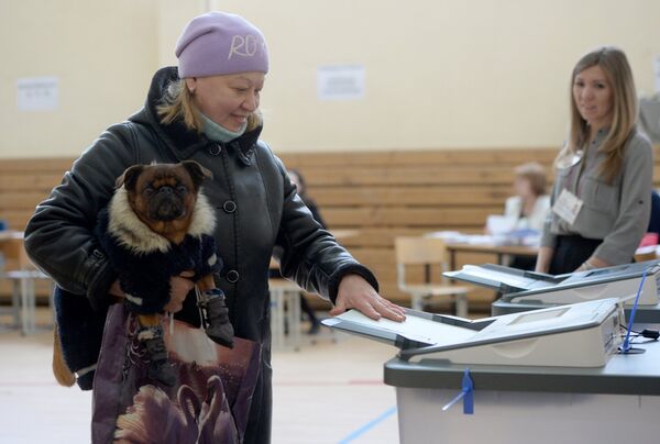 Женщина опускает бюллетень в урну на выборах президента РФ на избирательном участке №1331 в Екатеринбурге. 18 марта 2018