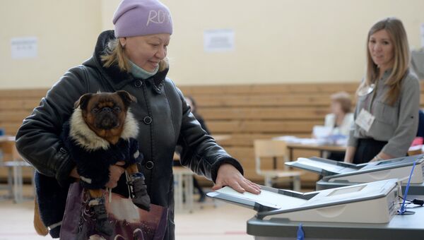 Женщина опускает бюллетень в урну на выборах президента РФ на избирательном участке №1331 в Екатеринбурге. 18 марта 2018