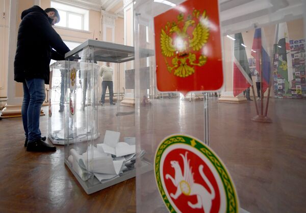 Мужчина опускает бюллетень в урну во время голосования на выборах президента Российской Федерации на избирательном участке №42 в Казани. 18 марта 2018