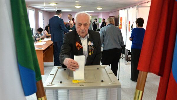Мужчина опускает бюллетень в урну на выборах президента РФ на избирательном участке в Хабаровске. 18 марта 2018