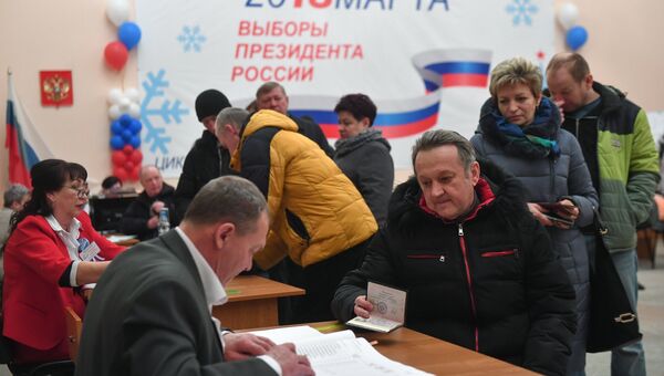 Избиратели во время голосования на выборах президента Российской Федерации на избирательном участке в Байконуре. 18 марта 2018