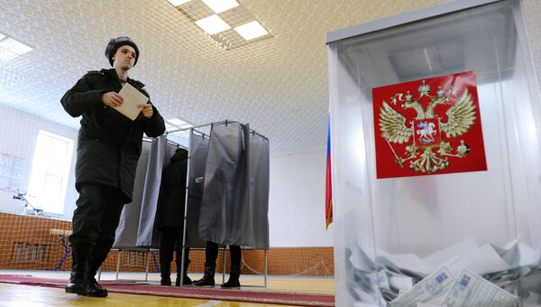 Военнослужащий голосует на выборах президента Российской Федерации на избирательном участке. 18 марта 2018