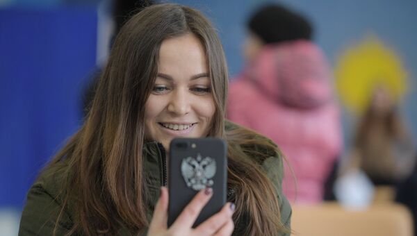 Девушка во время голосования на выборах президента РФ на избирательном участке № 90 в Москве. 18 марта 2018