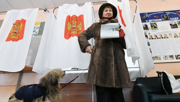 Женщина голосует на выборах президента РФ на избирательном участке в Москве. 18 марта 2018