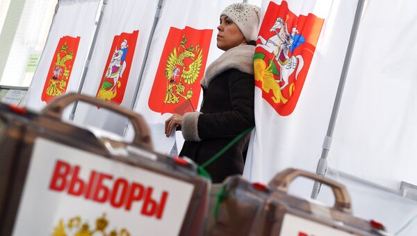 Девушка во время голосования на выборах президента РФ на избирательном участке №13-06 в Москве. 18 марта 2018