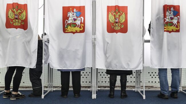 Избиратели во время голосования на выборах на избирательном участке №13-06 в Москве. Архивное фото