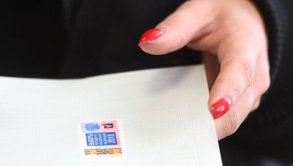 Женщина голосует на выборах президента РФ на избирательном участке. 18 марта 2018