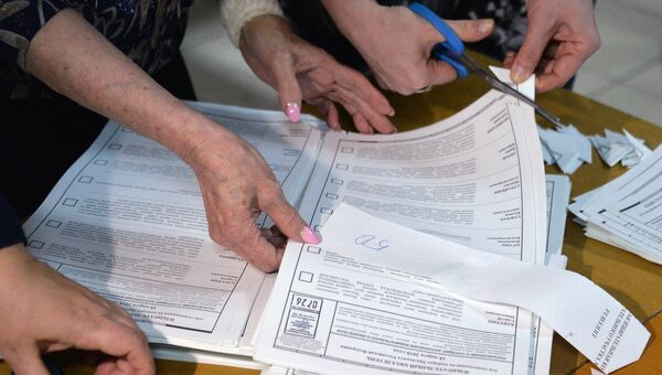Члены избирательной комиссии аннулируют неиспользованные бюллетени во время подсчета голосов на одном из избирательных участков во Владивостоке. 18 марта 2018