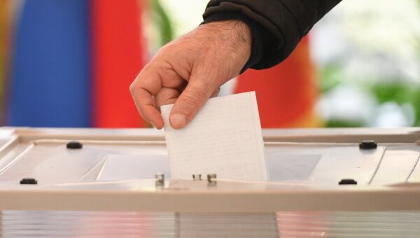 Мужчина голосует на выборах президента Российской Федерации на избирательном участке