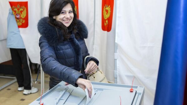 Женщина голосует на выборах президента РФ на избирательном участке в посольстве РФ в Кишиневе. 18 марта 2018