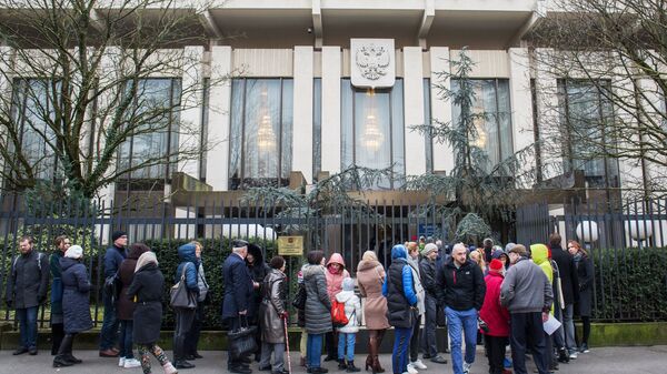 Избиратели у здания посольства России во Франции, где проходит голосование на выборах президента России. 18 марта 2018