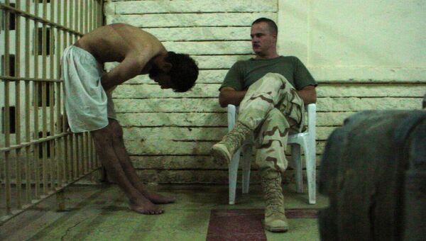 Американский военный и заключенный тюрьмы Абу-Грейб в Багдаде, Ирак. 2003