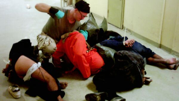 Американский военный избивает заключенных в тюрьме Абу-Грейб в Багдаде, Ирак. 2003