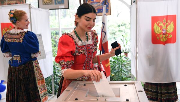 Девушки в национальных костюмах голосуют на выборах президента Российской Федерации на избирательном участке №4660 в Сочи