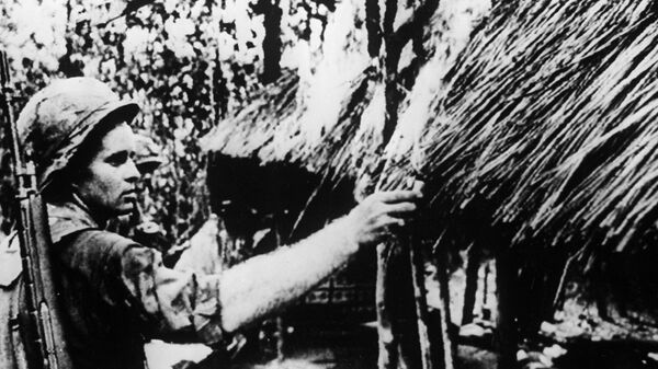 Американский солдат поджигает хижину в одной из вьетнамских деревень. Вьетнамская война (1957-1975 гг.)
