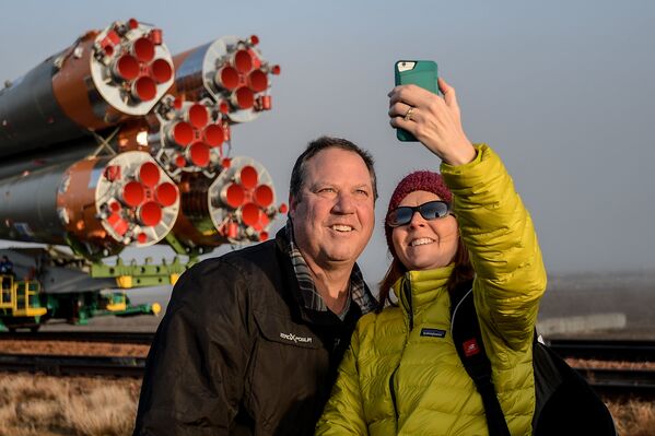 Журналисты фотографируются на фоне ракеты-носителя Союз-ФГ c транспортно-пилотируемым кораблем Союз МС-08 на стартовую площадку космодрома Байконур
