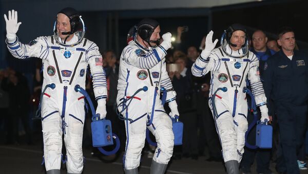 Члены основного экипажа корабля Союз МС-08 экспедиции МКС-55/56 астронавт НАСА Рики Арнольд, космонавт Роскосмоса Олег Артемьев и астронавт НАСА Эндрю Фойстел (слева направо)  перед посадкой в автобус перед отъездом на стартовую площадку космодрома Байконур