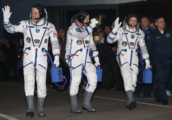 Члены основного экипажа корабля Союз МС-08 экспедиции МКС-55/56 астронавт НАСА Рики Арнольд, космонавт Роскосмоса Олег Артемьев и астронавт НАСА Эндрю Фойстел (слева направо)  перед посадкой в автобус перед отъездом на стартовую площадку космодрома Байконур