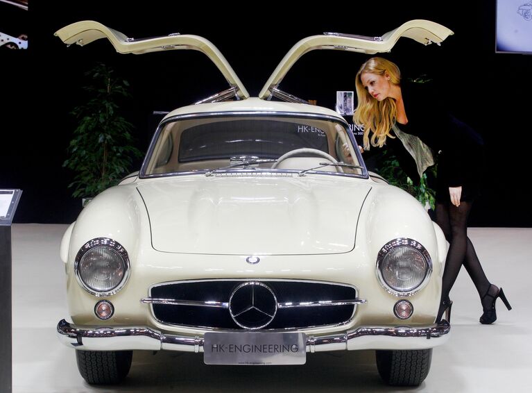 Девушка рядом с автомобилем Mercedes-Benz 300 SL Coupe 1956 года на выставке Techno-Classica Essen в Германии