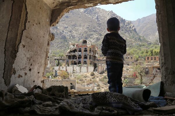 Ребенок в разрушенных после авиаудара зданиях в городе Таиз, Йемен
