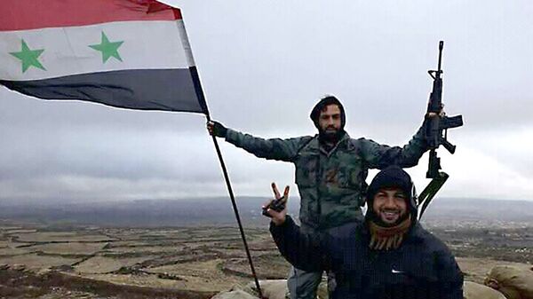 Солдаты сирийской армии с флагом Сирии. 2 января 2018