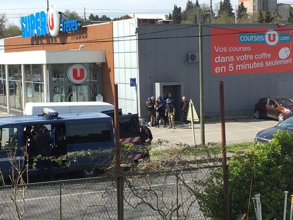 Сотрудники полиции у супермаркета Super U в коммуне Треб на юге Франции, где произошел захват заложников. 23 марта 2018 Сотрудники полиции у супермаркета Super U в коммуне Треб на юге Франции, где произошел захват заложников. 23 марта 2018