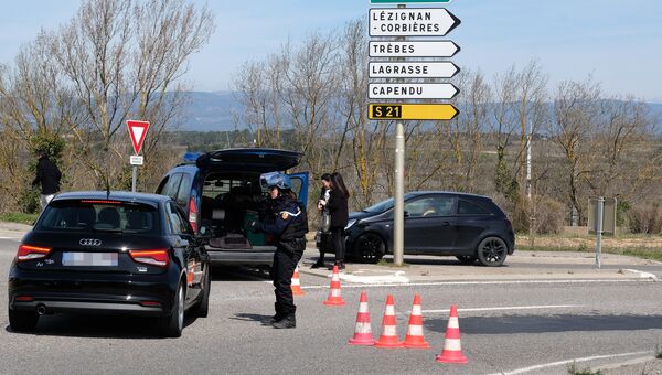 Сотрудники правоохранительных органов на въезде в коммуну Треб на юге Франции, где произошел захват заложников. 23 марта 2018