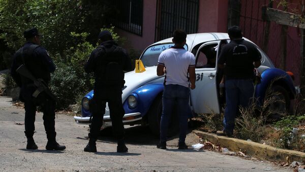 Судебный работник осматривает тело водителя такси, застреленного неизвестными нападавшими в Акапулько, Мексика. 23 марта 2018