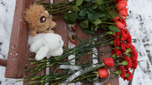 Цветы, свечи и мягкие игрушки возле здания торгового центра «Зимняя вишня» в Кемерово, где произошел пожар. 26 марта 2018