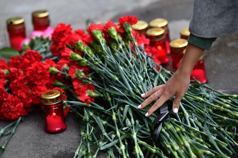 Цветы и свечи в память о погибших в ТЦ Зимняя вишня у здания представительства Кемеровской области в Москве. 26 марта 2018