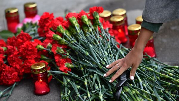 Цветы и свечи в память о погибших в ТЦ Зимняя вишня