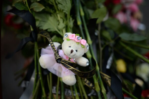 Цветы и мягкие игрушки возле здания торгового центра «Зимняя вишня» в Кемерово, где произошел пожар