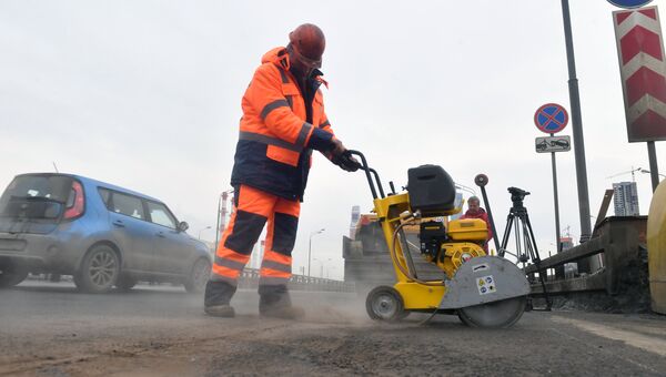 Рабочие ремонтируют участок дороги в Москве
