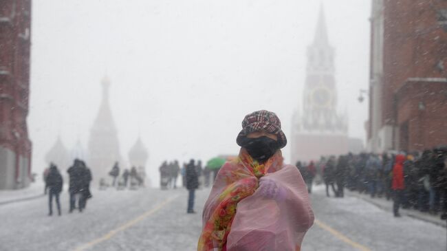 Туристка во время снегопада на Красной площади в Москве. 27 марта 2018