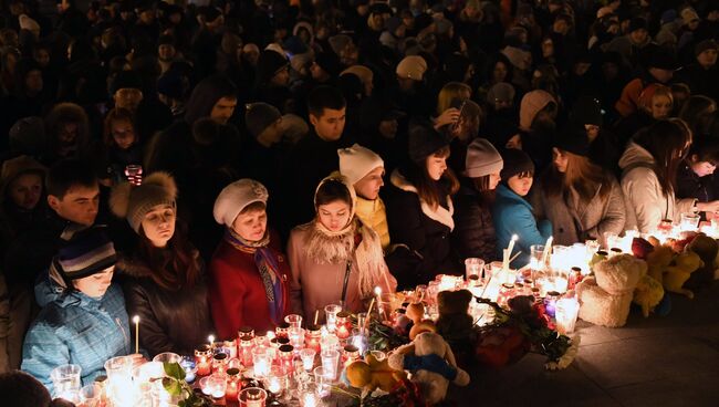 Участники акции зажигают свечи в память в память о погибших при пожаре в кемеровском торговом центре Зимняя вишня. Архивное фото