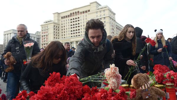 Люди возлагают цветы к мемориалу на Манежной площади в Москве в память о погибших в кемеровском торговом центре. Архивное фото