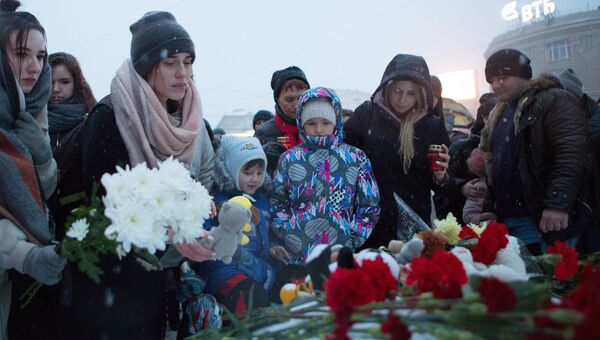 Люди возлагают цветы к мемориалу у памятника И. С. Никитину в Воронеже в память о погибших в ТЦ Зимняя вишня в Кемерово