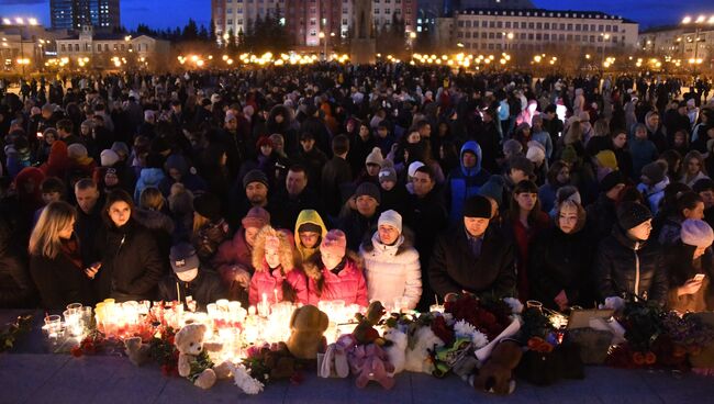 Участники акции на площади Ленина в Чите зажигают свечи в память о погибших при пожаре в торговом центре Зимняя вишня в Кемерово. Архивное фото