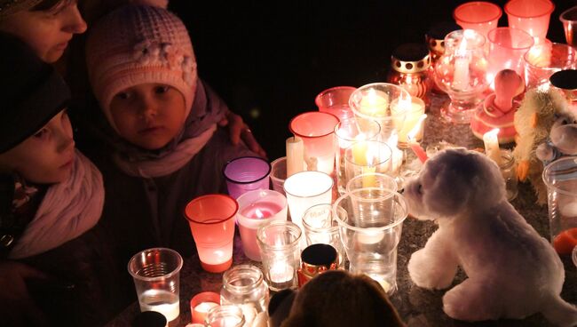 Участники акции зажигают свечи в память о погибших при пожаре в торговом центре Зимняя вишня в Кемерово