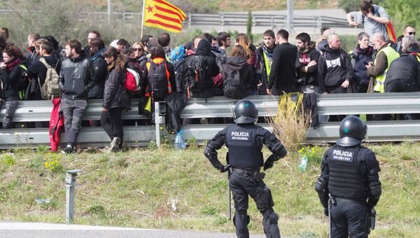 Полиция и протестующие, перекрывшие трассу между Испанией и Францией в районе Фигераса. 27 марта 2018