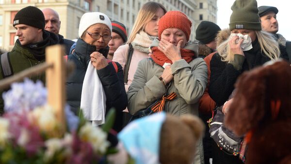 Люди у мемориала на Манежной площади в Москве, организованного в память о погибших в ТЦ Зимняя вишня